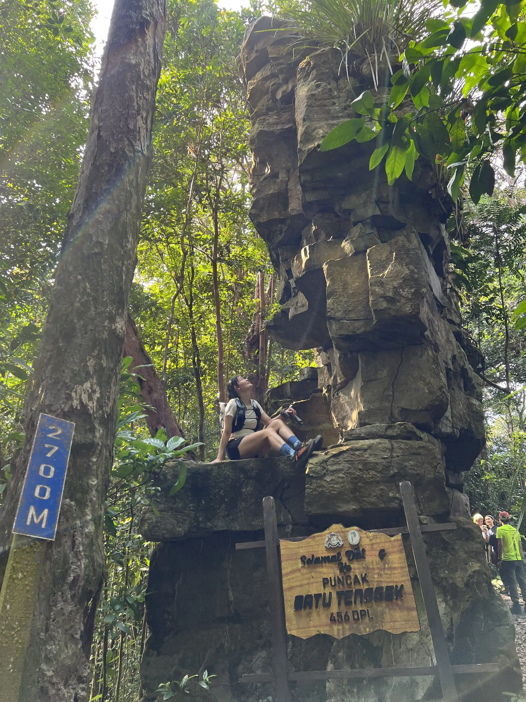 石叠石 Batu Tenggek，团员坐在两层楼高的天然叠石上，下方是 Puncak Batu Tenggek 牌子