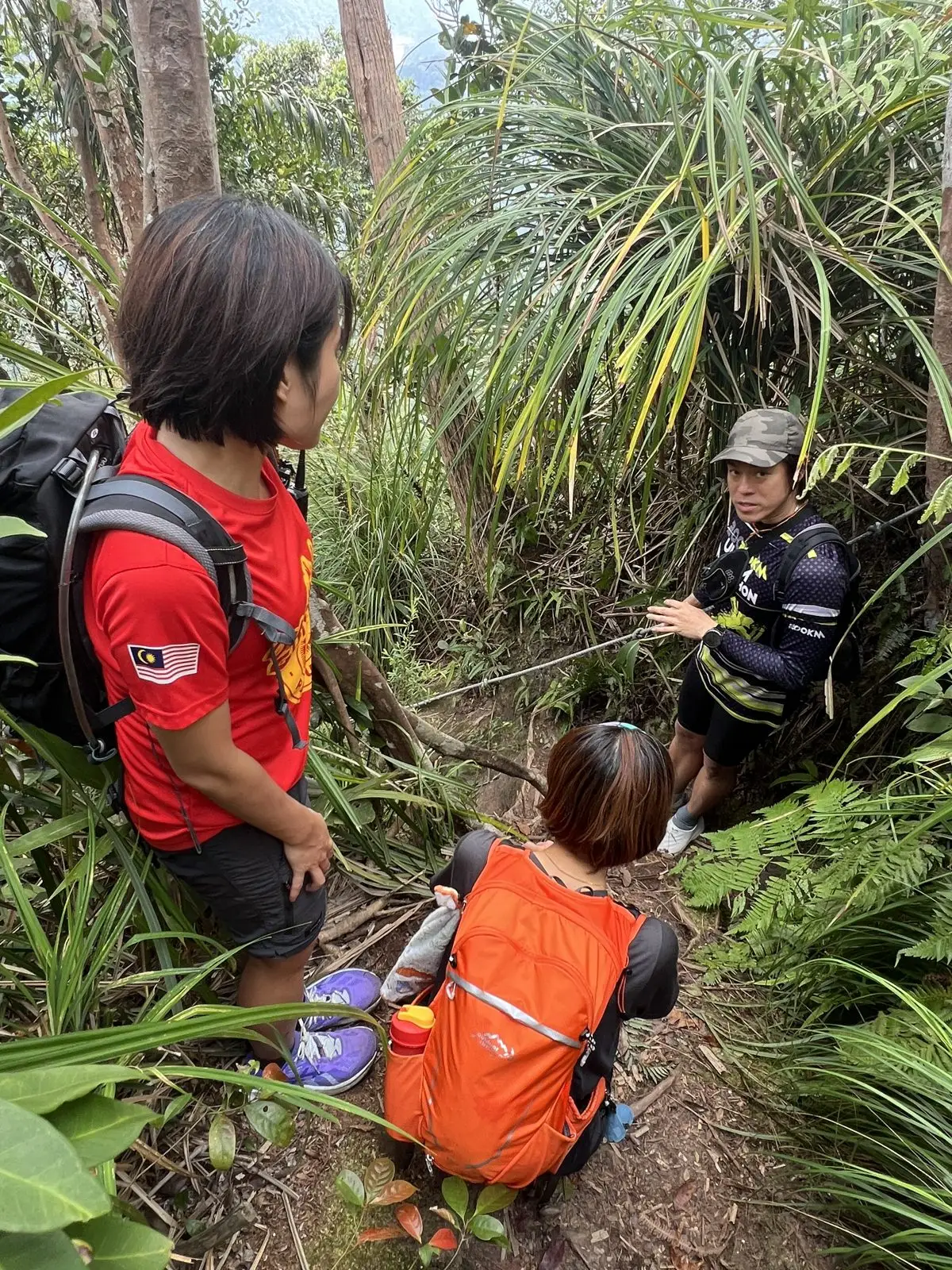 陡坡路段有绳索辅助，山导在旁边指导团员通过